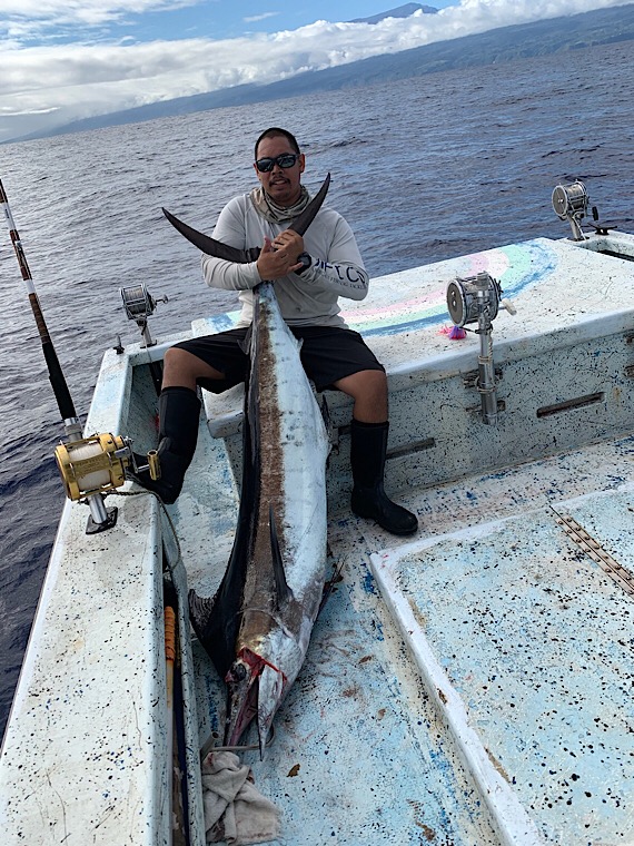 Angler seated aboard Rainbow Runner with a marlin catch in 2019