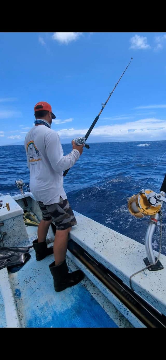Angler working a rod from the stern of Rainbow Runner
