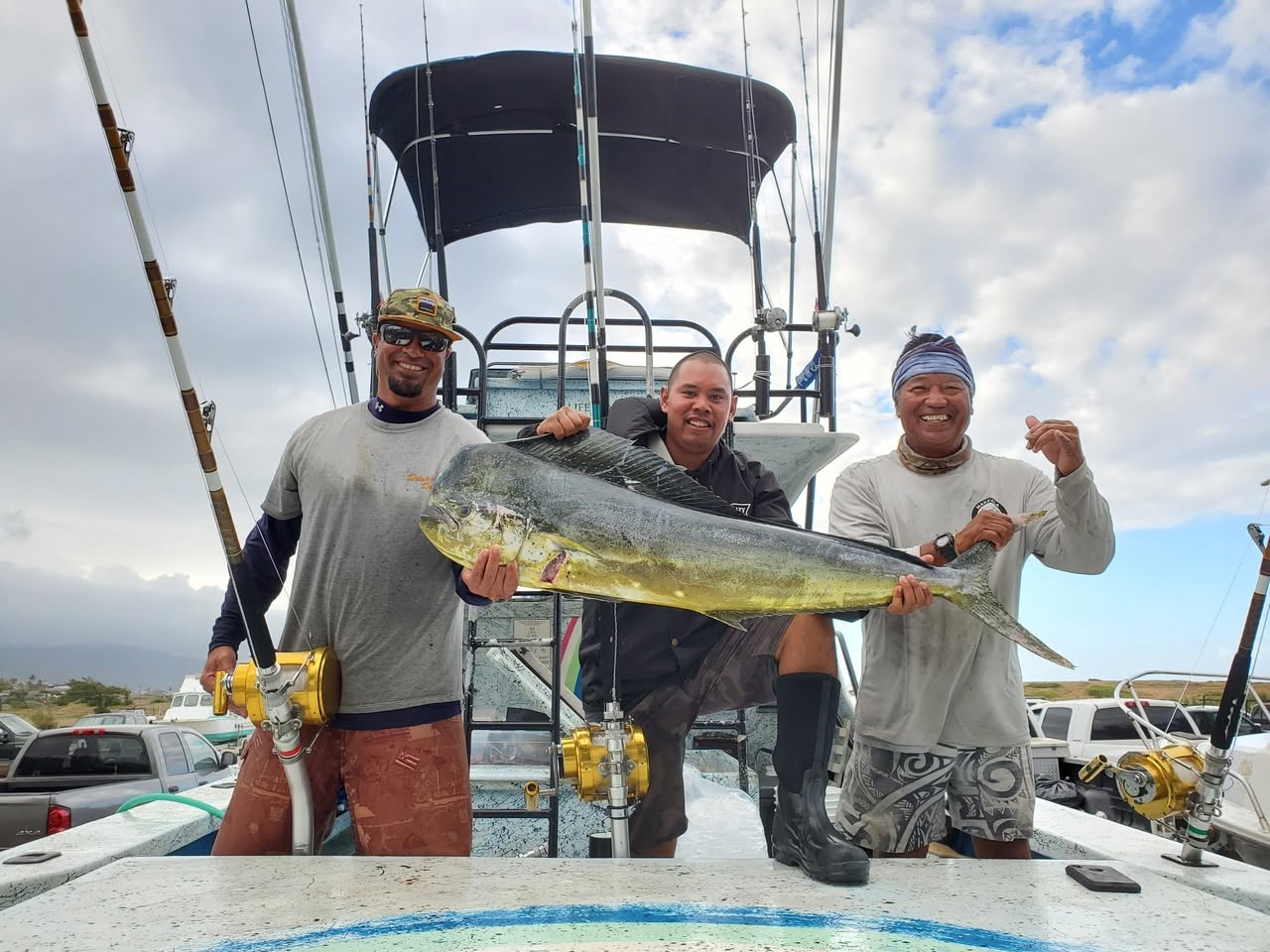 Three Rainbow Runner crew members holding the 2019 Mahi Classic mahi catch