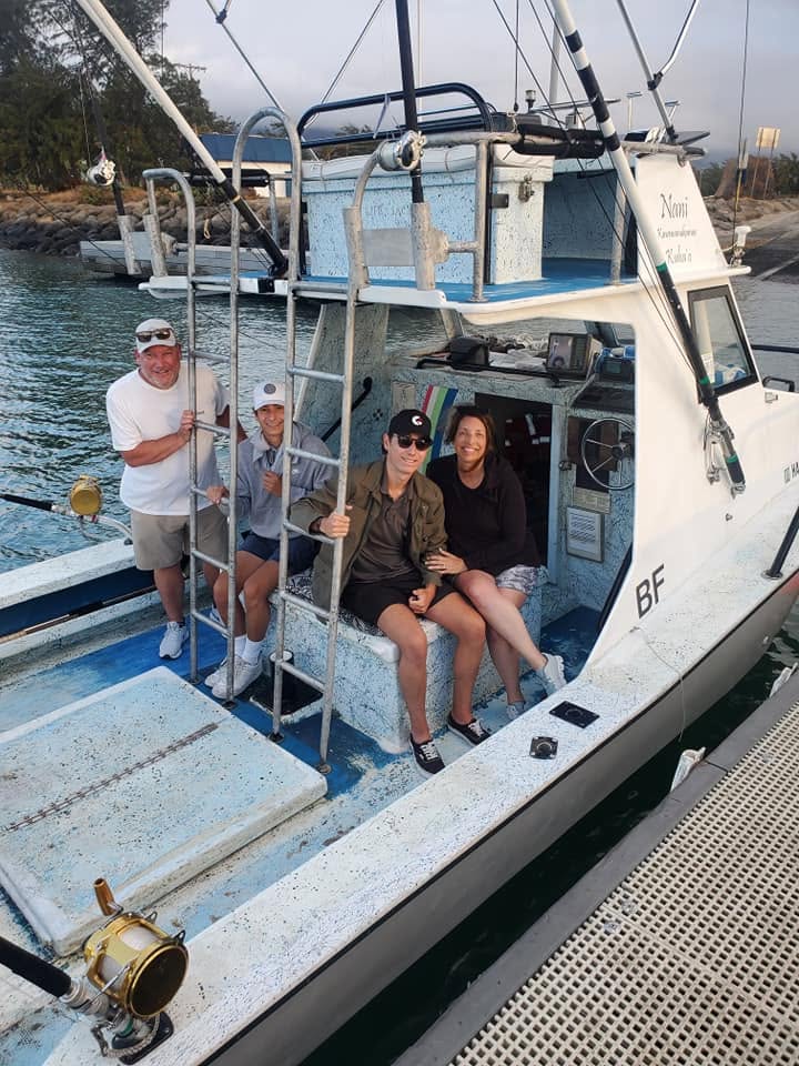 Four guests seated and standing in the Rainbow Runner cockpit at the dock
