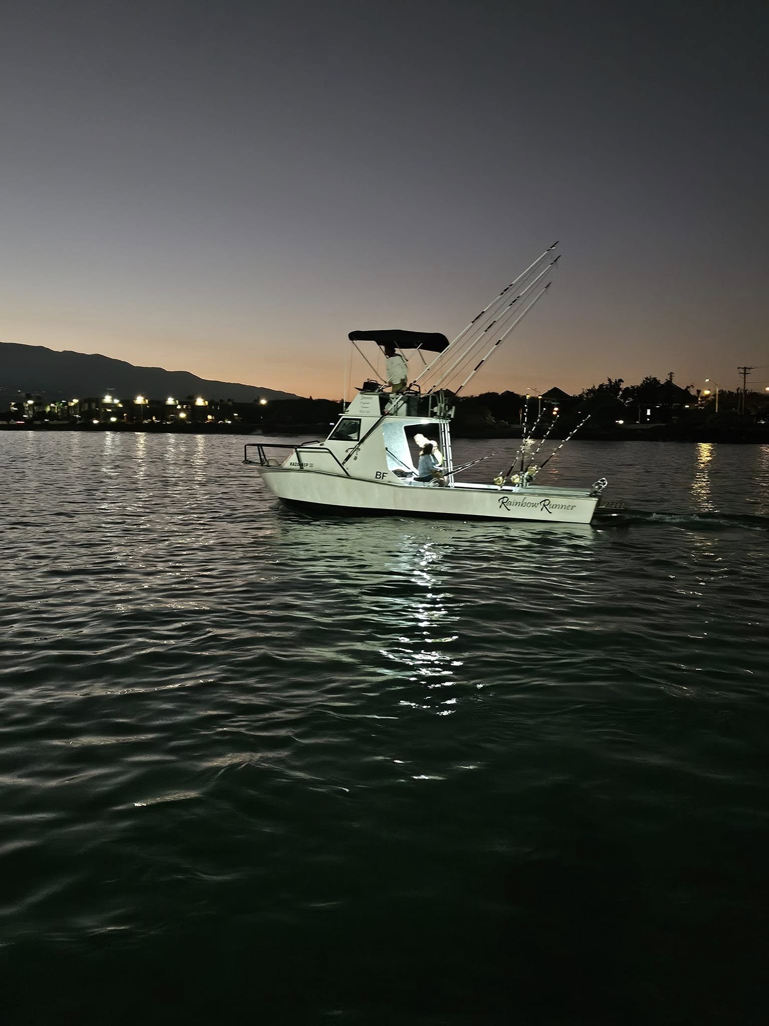 Rainbow Runner moving through Kahului Harbor after sunset