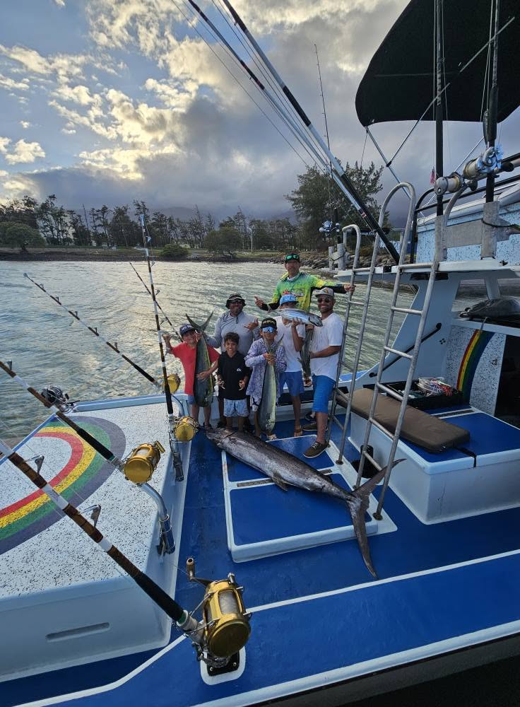 A group aboard Rainbow Runner standing behind a large billfish laid across the deck