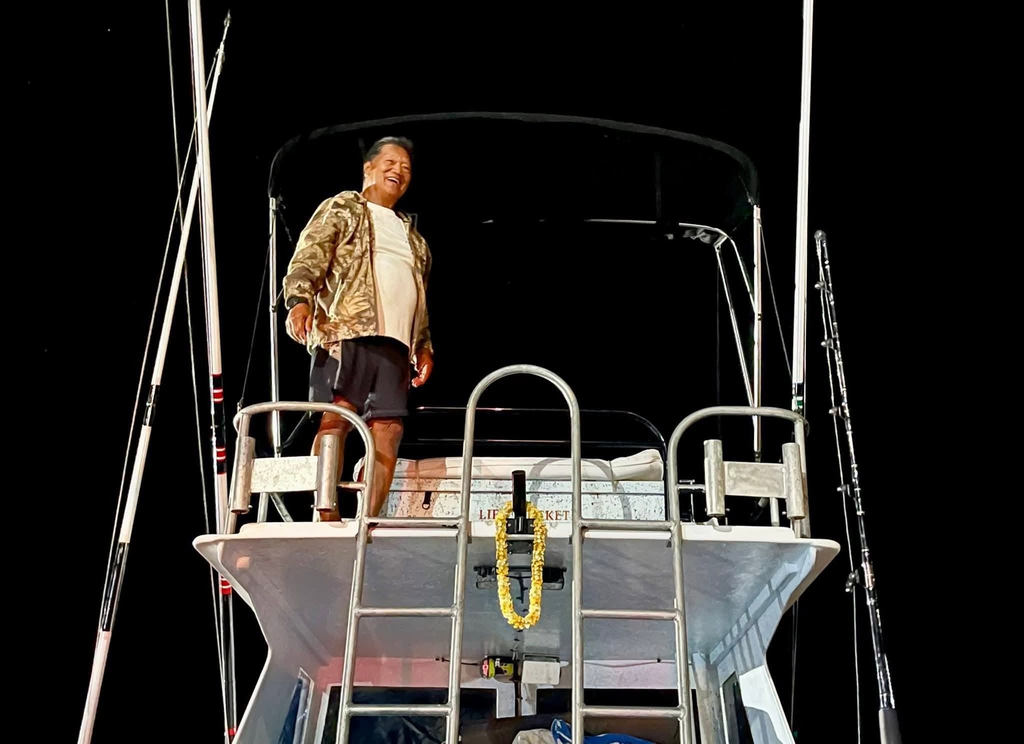 A man smiling from Rainbow Runner’s tower at night