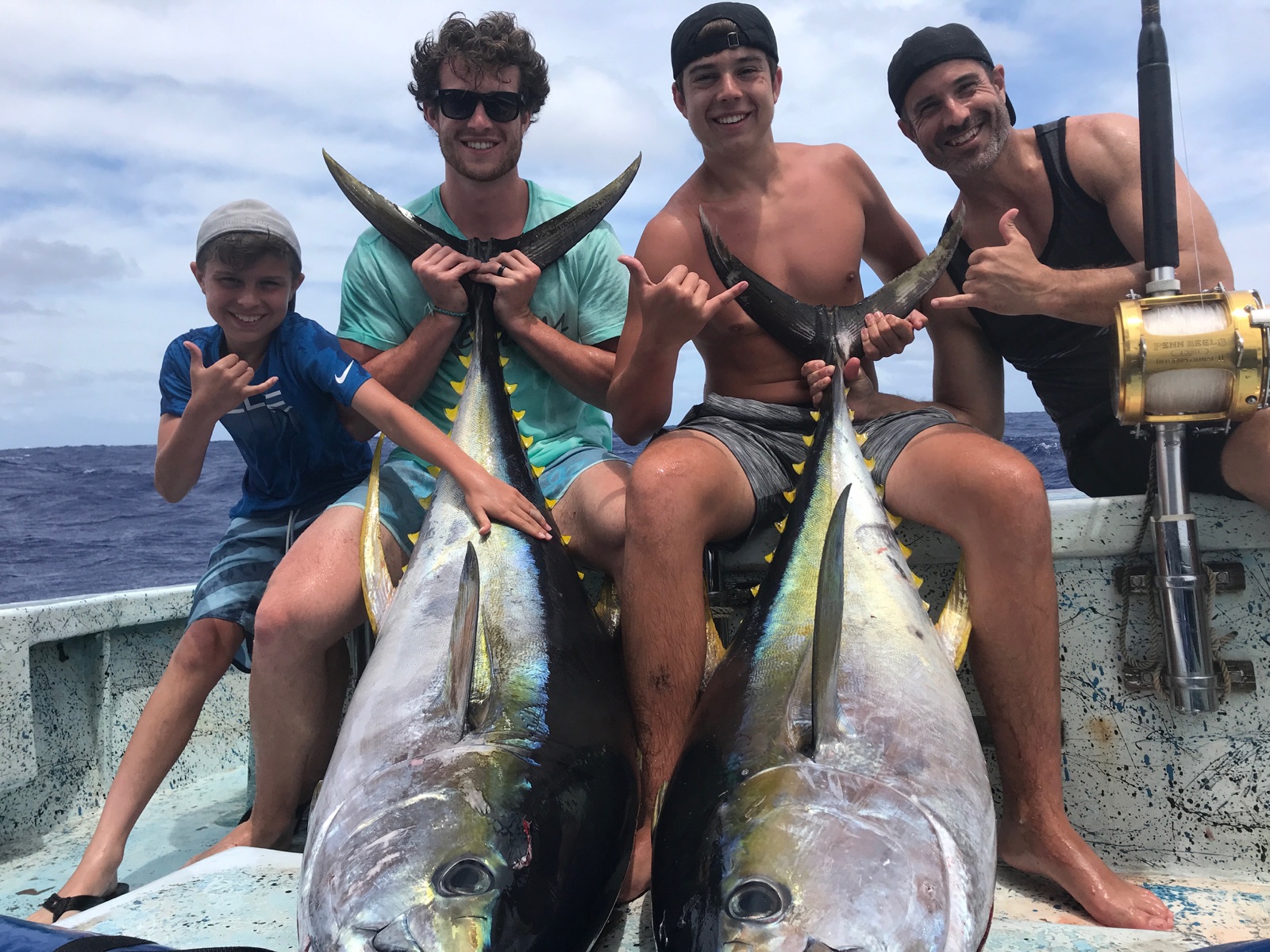 Four anglers with two yellowfin tuna aboard a fishing boat